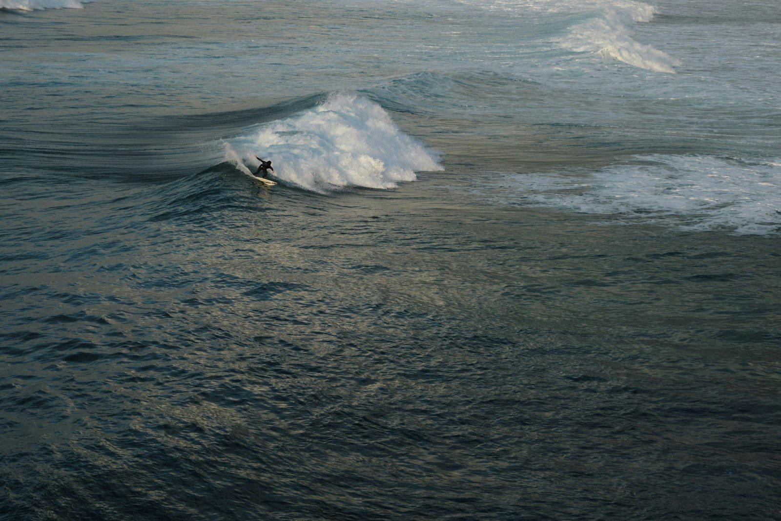 A person riding a surfboard on a wave in the ocean
