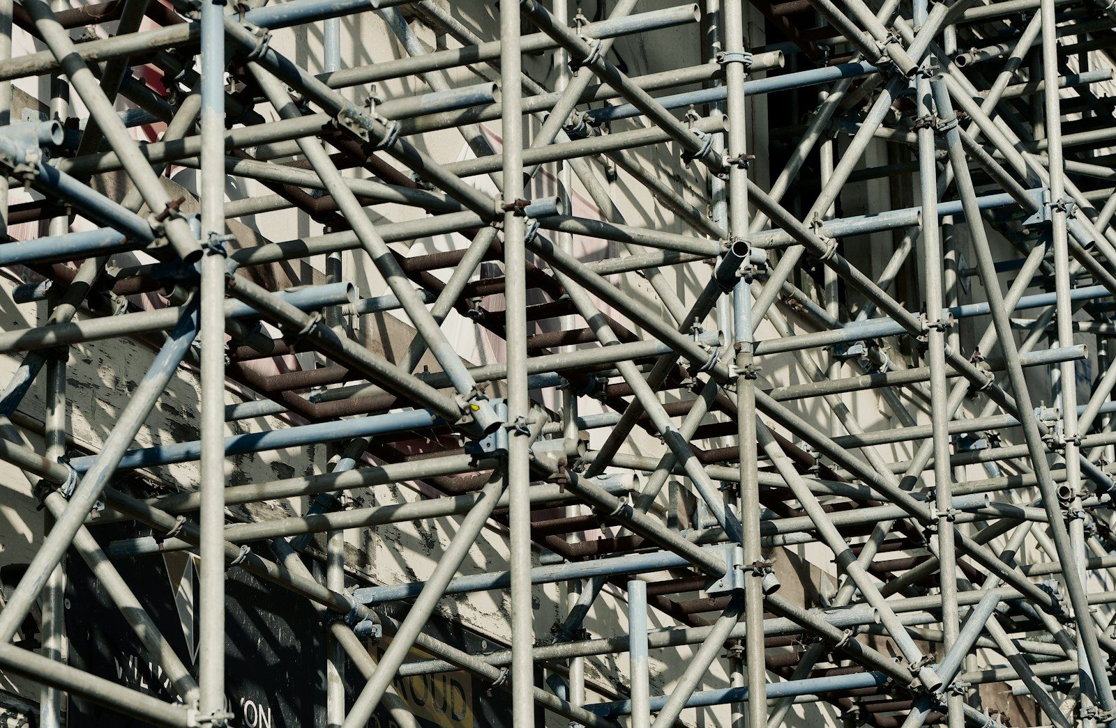 A large metal scaffolding with a clock on top of it
